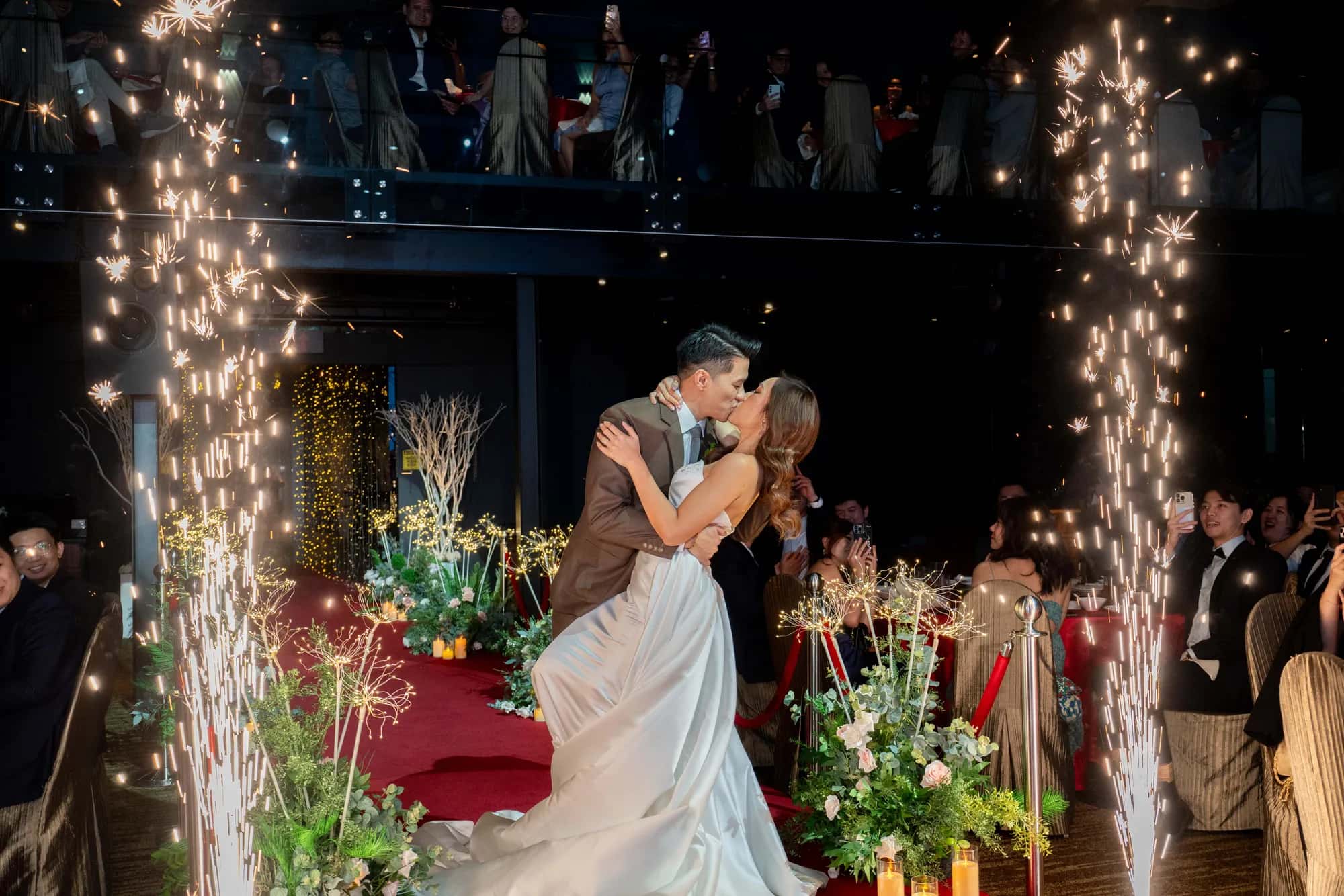 Wedding couple kissing during a sparkler entrance