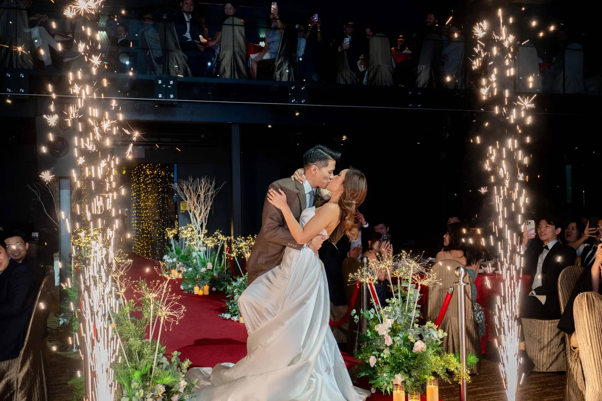 Wedding couple kissing during a sparkler entrance